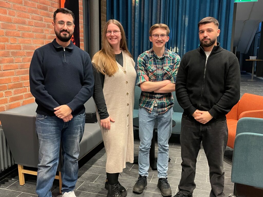 Programmeringsklubben, tre män och en kvinna tittar mot kameran